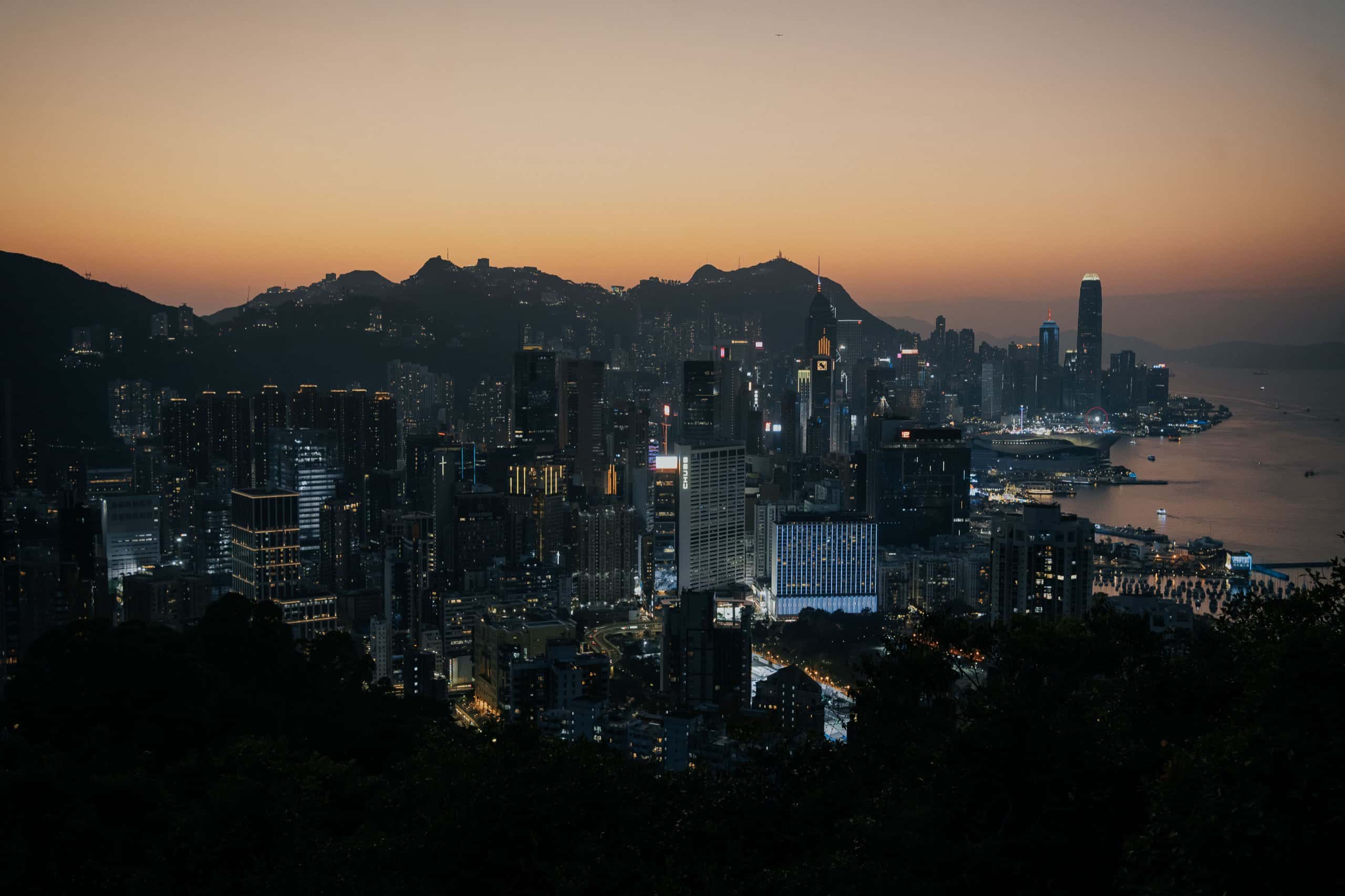 黃昏的香港天際線，維多利亞港兩岸的燈火漸次亮起