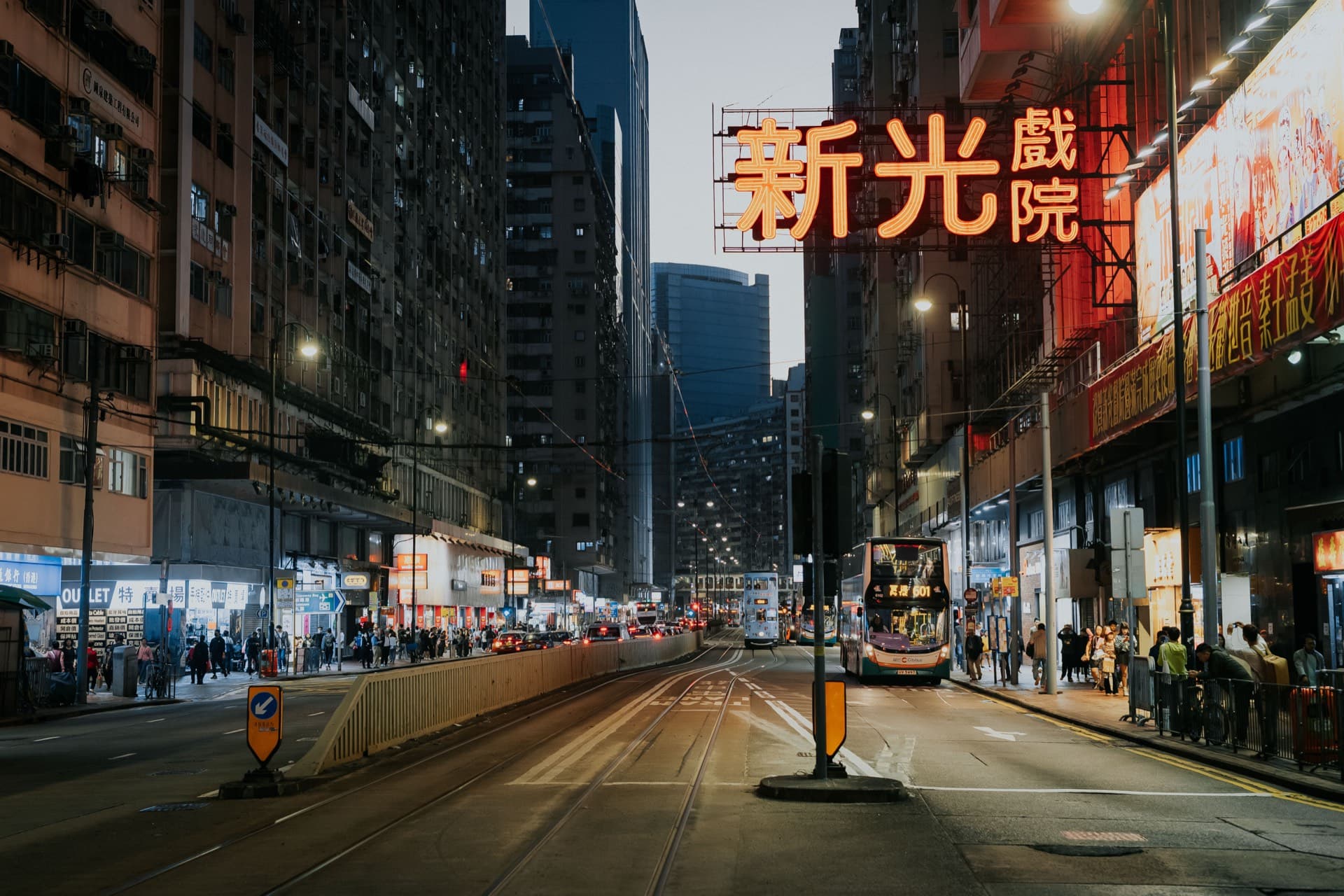 黃昏的北角街頭，電車駛過新光戲院的霓虹招牌