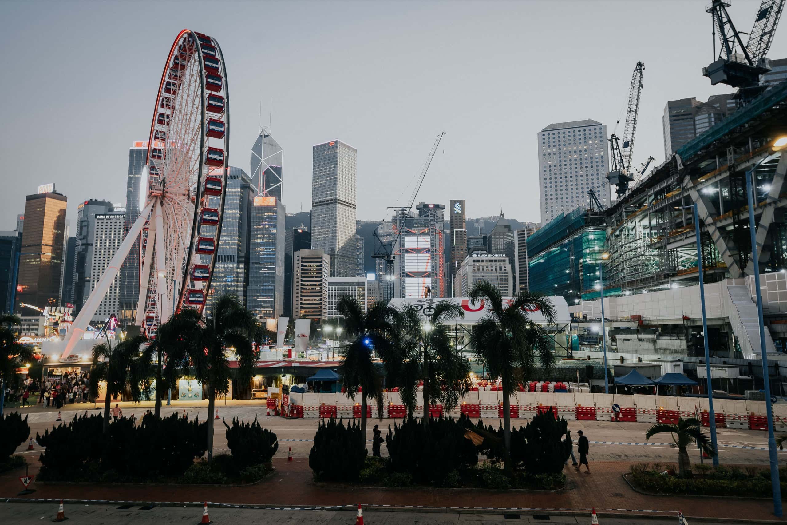 The Central harbourfront at dusk, with the observation wheel against the business-district skyline