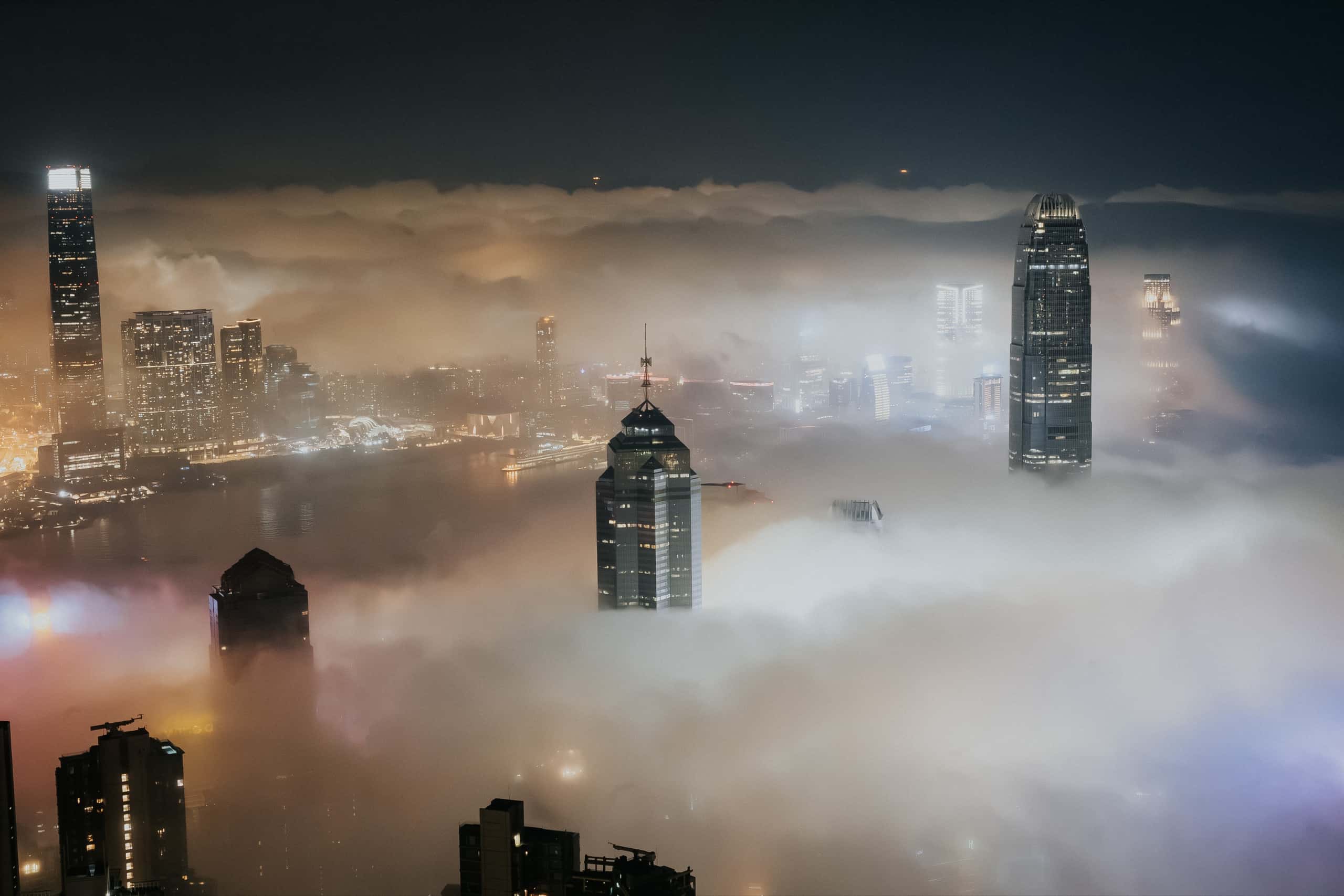 雲海之上的香港天際線,摩天大樓在夜霧中透出燈光