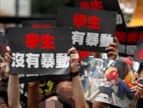 集會現場照片:人群高舉印有中文標語的黑色紙牌