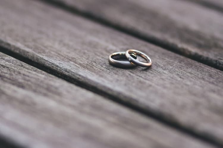 兩枚結婚戒指並排放在木製檯面上